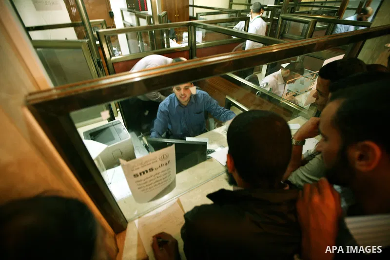 Palestinian Authority civil servants gather outside the Islamic Bank in Gaza city on Nov. 03,2011, to withdraw their monthly salaries. Photo by Mahmud Nassar
