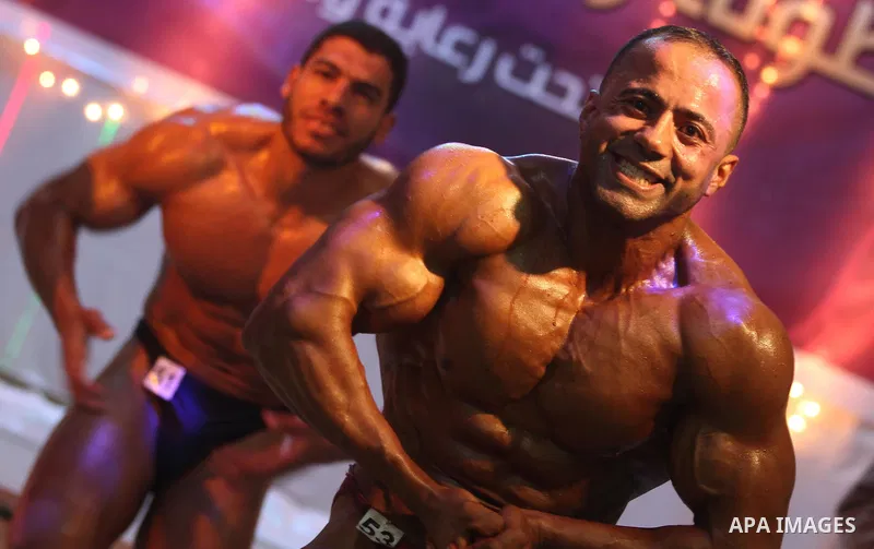 Palestinian men take part during competing in a bodybuilding contest at a hall in Gaza city, Nov. 3, 2011. Many of the men use women's cosmetics, mud, or paint to enhance their muscles. Number of men from around the Gaza...