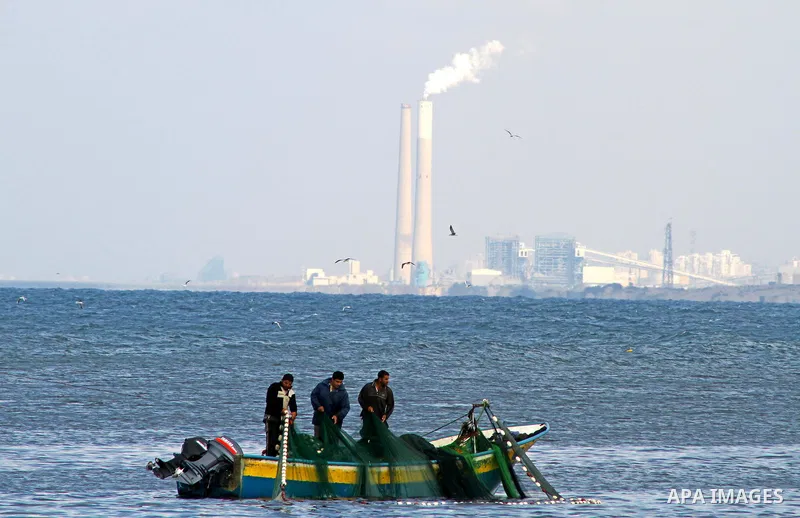 Palestinian fishermen cast their nets at the Gaza Seaport, as Israel's power station located in the southern city of Ashkelon is seen in the background, November 4, 2011. The United States warned on Thursday that a new e...