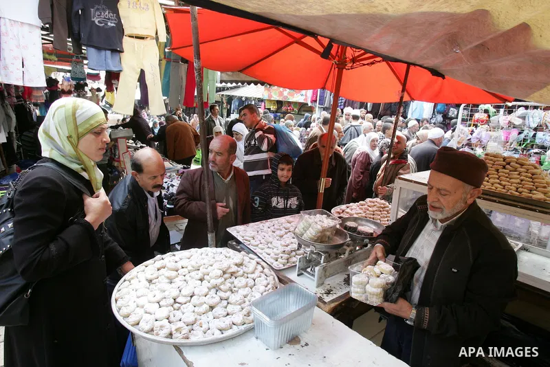 Palestinians shop in front of the Damascus gate in Jerusalem's old city on Nov. 4,2011, ahead of the Muslim Eid al-Adha festival at the end of the week. Muslims across the world are preparing to celebrate the annual "Fes...