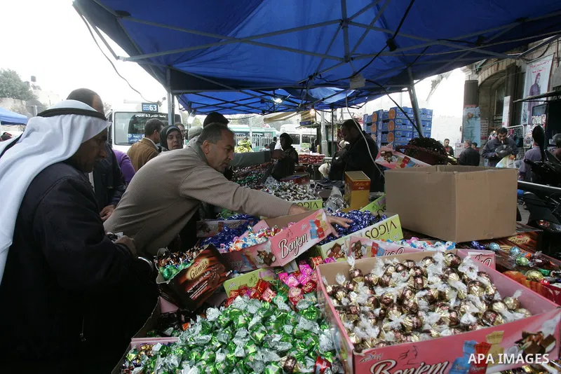Palestinians shop in front of the Damascus gate in Jerusalem's old city on Nov. 4,2011, ahead of the Muslim Eid al-Adha festival at the end of the week. Muslims across the world are preparing to celebrate the annual "Fes...