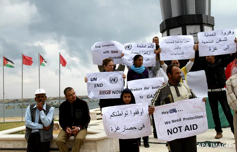 Palestinians hold placards during a rally to show their support for a two boat flotilla attempt to reach the Gaza Strip, in the port of Gaza City Friday, Nov. 4, 2011. Israel's military says the navy has boarded two prot...