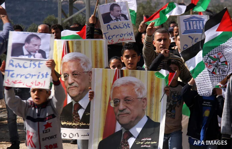 Palestinian demonstrators from the village of Kfar Kadum rally on November 4, 2011 in the Israeli-occupied West Bank as they hold pictures of Palestinian president Mahmud Abbas and Israeli Foreign Minister Avigdor Liberm...