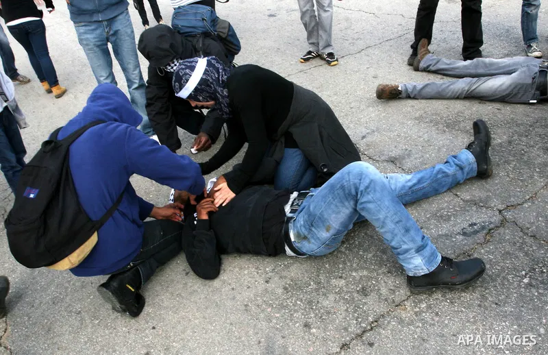 A Palestinian man is treated during clashes between Israeli forces and Palestinian stone throwers following a weekly demonstration against Israeli settlement expansion, in the West Bank village of Nabi Saleh on November...
