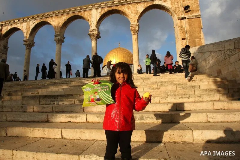 Palestinians walk in front of the Dome of the Rock on the compound known to Muslims as al-Haram al-Sharif, and to Jews as Temple Mount, in Jerusalem's Old city, on the first day of Eid al-Adha November 6, 2011. Muslims a...
