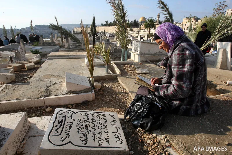 Palestinian woman prays next to a grave at a Muslim cemetery just outside Jerusalem's Old city on the first day of Eid al-Adha November 6, 2011. Muslims around the world celebrate Eid al-Adha to mark the end of the Hajj....