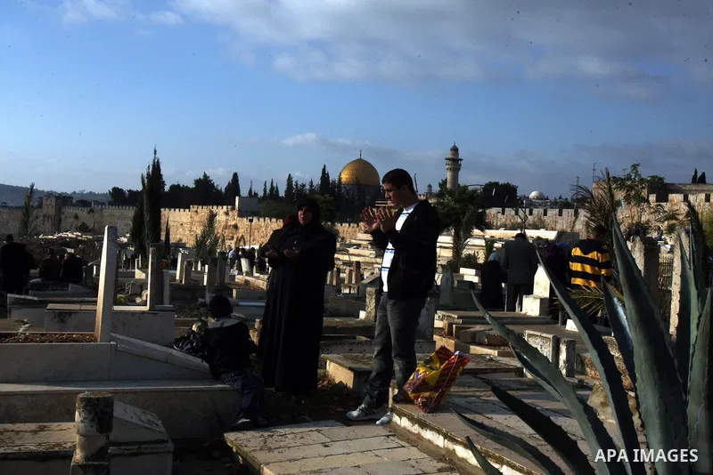 Palestinians visit the graves at a Muslim cemetery just outside Jerusalem's Old city on the first day of Eid al-Adha November 6, 2011. Muslims around the world celebrate Eid al-Adha to mark the end of the Hajj. The Dome...