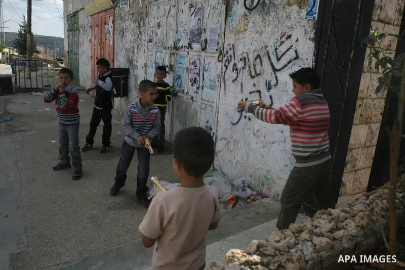 A Palestinians boys play with a toy gun in the West Bank city of Ramallah Nov.06, 2011. Muslims worldwide celebrate Eid al-Adha, or the Feast of the Sacrifice, by sacrificial killings of livestock to commemorate a religi...