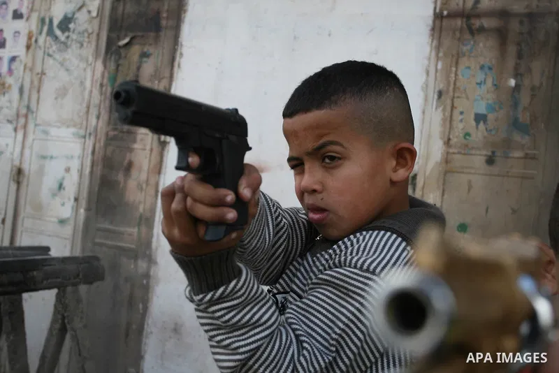 A Palestinians boys play with a toy gun in the West Bank city of Ramallah Nov.06, 2011. Muslims worldwide celebrate Eid al-Adha, or the Feast of the Sacrifice, by sacrificial killings of livestock to commemorate a religi...