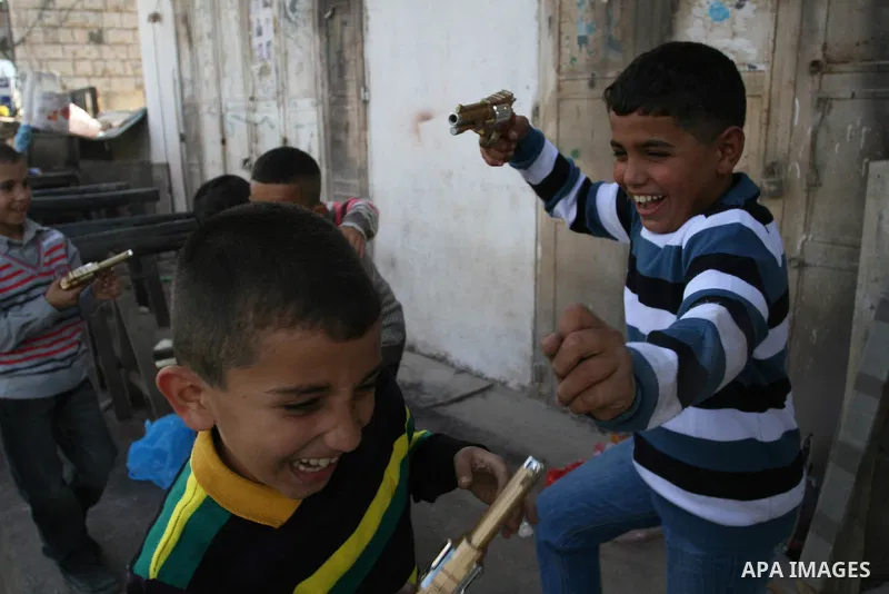 A Palestinians boys play with a toy gun in the West Bank city of Ramallah Nov.06, 2011. Muslims worldwide celebrate Eid al-Adha, or the Feast of the Sacrifice, by sacrificial killings of livestock to commemorate a religi...