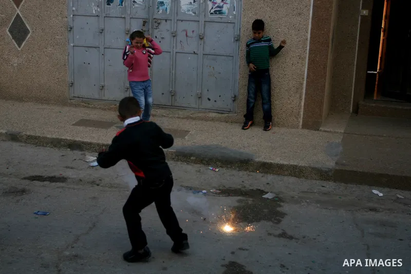 A Palestinians boys play with a toy gun in the West Bank city of Ramallah Nov.06, 2011. Muslims worldwide celebrate Eid al-Adha, or the Feast of the Sacrifice, by sacrificial killings of livestock to commemorate a religi...