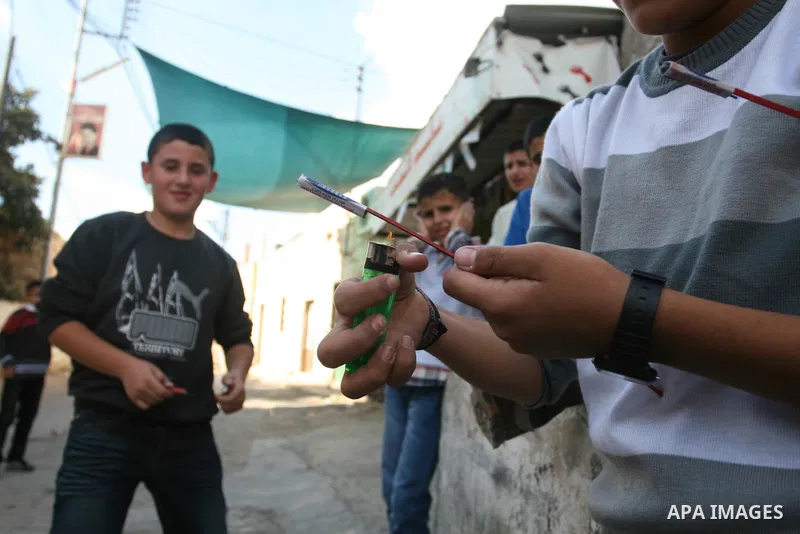 A Palestinians boys play with a toy gun in the West Bank city of Ramallah Nov.06, 2011. Muslims worldwide celebrate Eid al-Adha, or the Feast of the Sacrifice, by sacrificial killings of livestock to commemorate a religi...