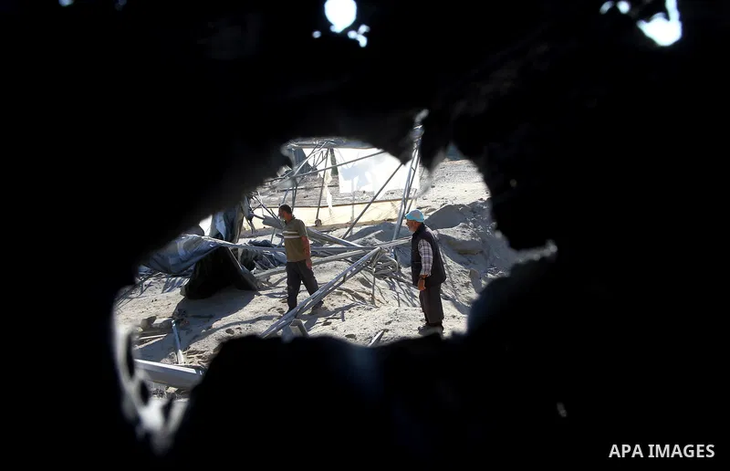Palestinians remove rubble after an overnight Israeli air strike in Khan Younis in the southern Gaza Strip November 9, 2011. The Israeli military said it targeted a militant facility in response to rocket fire by Gaza mi...