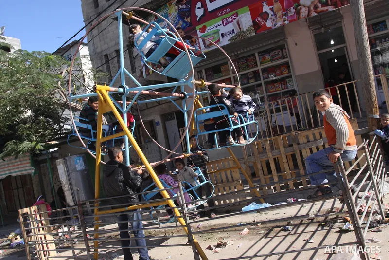 Palestinians children enjoy a ride in an amusement , during Eid al-Adha in Gaza City, Nov. 9, 2011. Muslims worldwide celebrate Eid al-Adha, or the Feast of the Sacrifice, with the sacrificial killing of livestock to com...