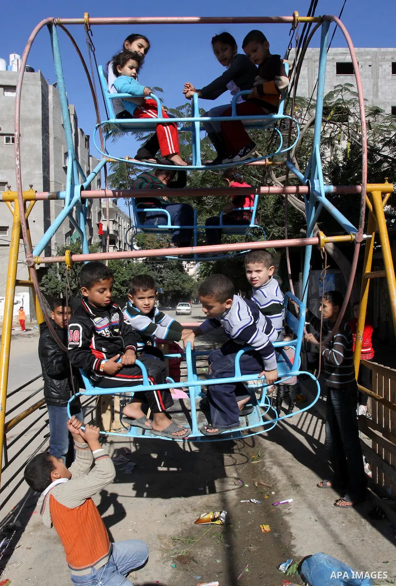 Palestinians children enjoy a ride in an amusement , during Eid al-Adha in Gaza City, Nov. 9, 2011. Muslims worldwide celebrate Eid al-Adha, or the Feast of the Sacrifice, with the sacrificial killing of livestock to com...