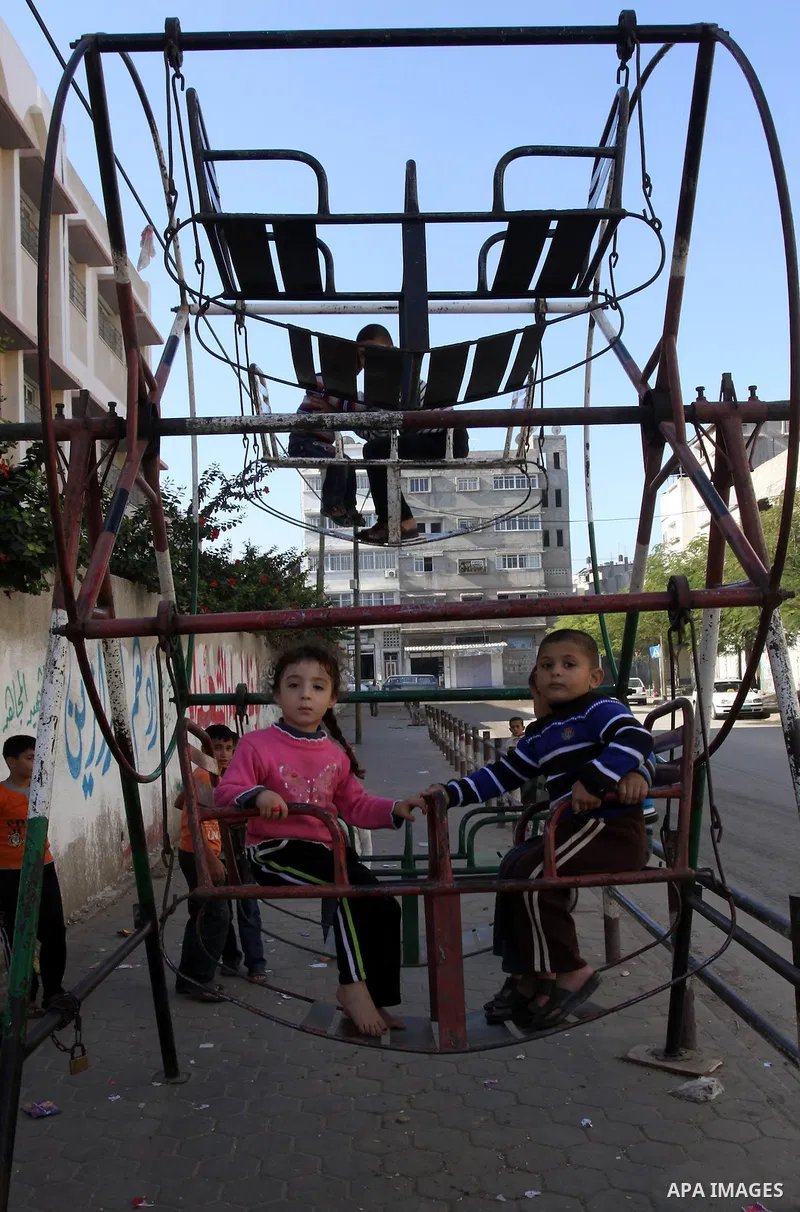 Palestinians children enjoy a ride in an amusement , during Eid al-Adha in Gaza City, Nov. 9, 2011. Muslims worldwide celebrate Eid al-Adha, or the Feast of the Sacrifice, with the sacrificial killing of livestock to com...