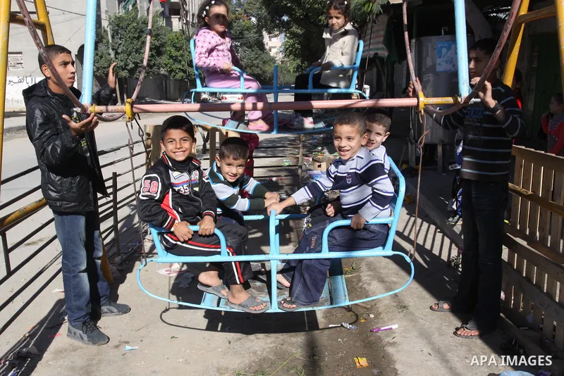 Palestinians children enjoy a ride in an amusement , during Eid al-Adha in Gaza City, Nov. 9, 2011. Muslims worldwide celebrate Eid al-Adha, or the Feast of the Sacrifice, with the sacrificial killing of livestock to com...