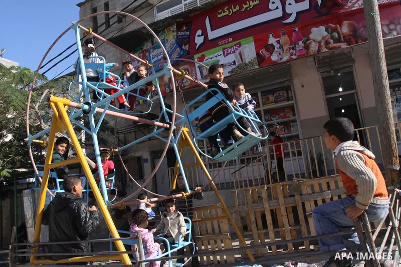 Palestinians children enjoy a ride in an amusement , during Eid al-Adha in Gaza City, Nov. 9, 2011. Muslims worldwide celebrate Eid al-Adha, or the Feast of the Sacrifice, with the sacrificial killing of livestock to com...