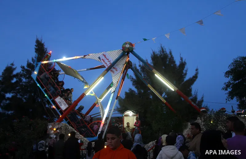 Palestinians enjoy a ride in an amusement park, during Eid al-Adha in Gaza City, Nov. 9, 2011. Muslims worldwide celebrate Eid al-Adha, or the Feast of the Sacrifice, with the sacrificial killing of livestock to commemor...