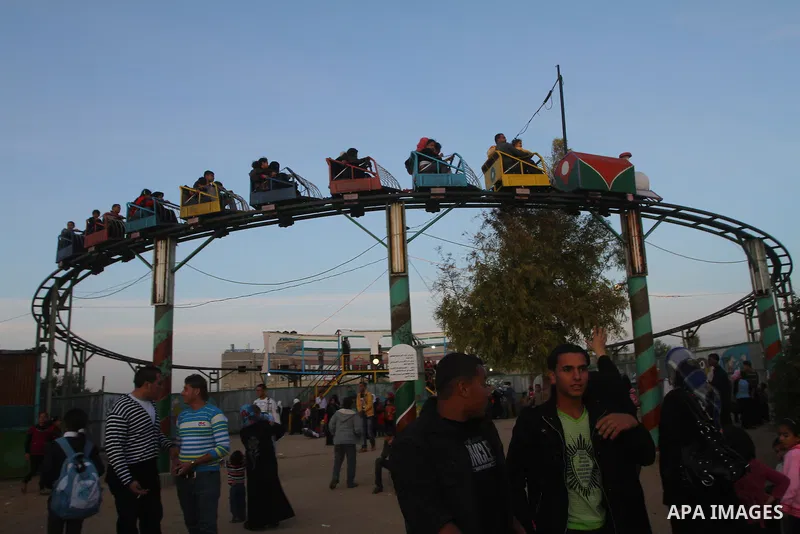 Palestinians enjoy a ride in an amusement park, during Eid al-Adha in Gaza City, Nov. 9, 2011. Muslims worldwide celebrate Eid al-Adha, or the Feast of the Sacrifice, with the sacrificial killing of livestock to commemor...