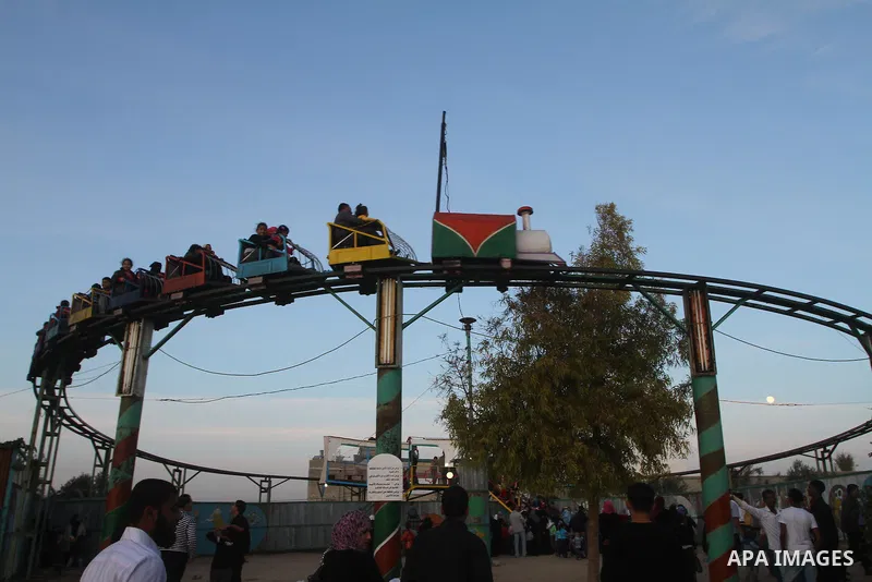 Palestinians enjoy a ride in an amusement park, during Eid al-Adha in Gaza City, Nov. 9, 2011. Muslims worldwide celebrate Eid al-Adha, or the Feast of the Sacrifice, with the sacrificial killing of livestock to commemor...