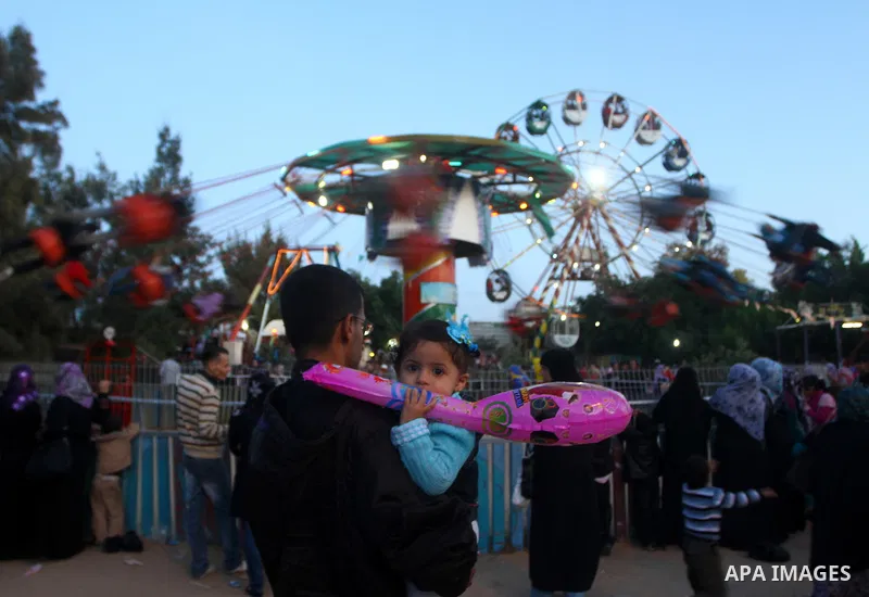 Palestinians enjoy a ride in an amusement park, during Eid al-Adha in Gaza City, Nov. 9, 2011. Muslims worldwide celebrate Eid al-Adha, or the Feast of the Sacrifice, with the sacrificial killing of livestock to commemor...