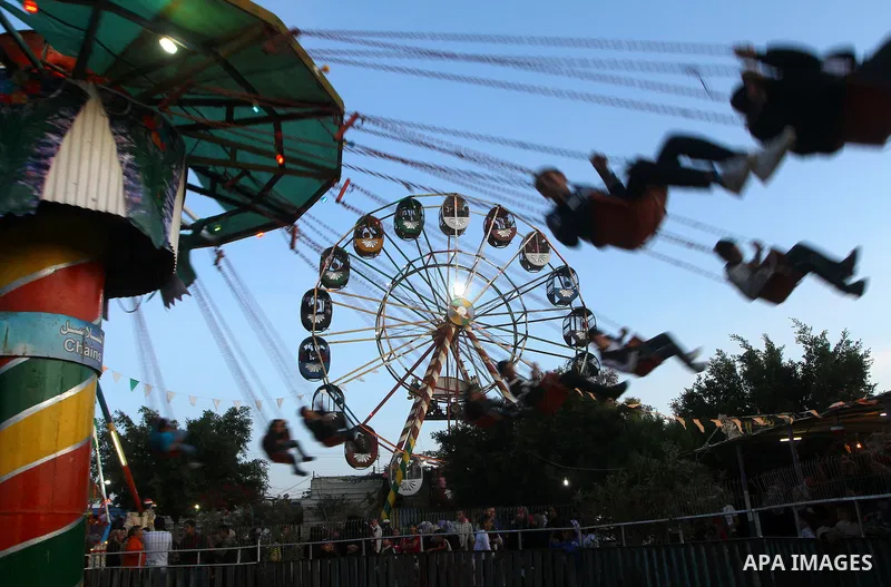 Palestinians enjoy a ride in an amusement park, during Eid al-Adha in Gaza City, Nov. 9, 2011. Muslims worldwide celebrate Eid al-Adha, or the Feast of the Sacrifice, with the sacrificial killing of livestock to commemor...