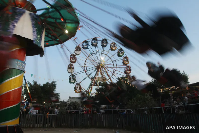Palestinians enjoy a ride in an amusement park, during Eid al-Adha in Gaza City, Nov. 9, 2011. Muslims worldwide celebrate Eid al-Adha, or the Feast of the Sacrifice, with the sacrificial killing of livestock to commemor...