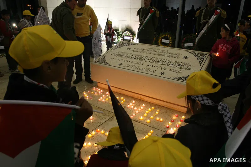 Palestinians lay flower wreathes and candles at the gravesite of late Palestinian leader Yasser Arafat on the seventh anniversary of his death in the West Bank city of Ramallah on November 11, 2011, as Palestinians gathe...