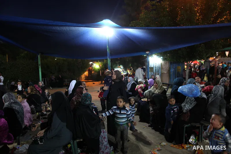 Palestinians enjoy a ride in an amusement park, during Eid al-Adha in Gaza City, Nov. 10, 2011. Muslims worldwide celebrate Eid al-Adha, or the Feast of the Sacrifice, with the sacrificial killing of livestock to commemo...