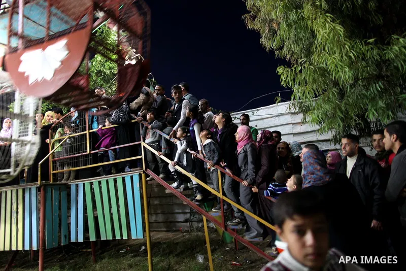 Palestinians enjoy a ride in an amusement park, during Eid al-Adha in Gaza City, Nov. 10, 2011. Muslims worldwide celebrate Eid al-Adha, or the Feast of the Sacrifice, with the sacrificial killing of livestock to commemo...
