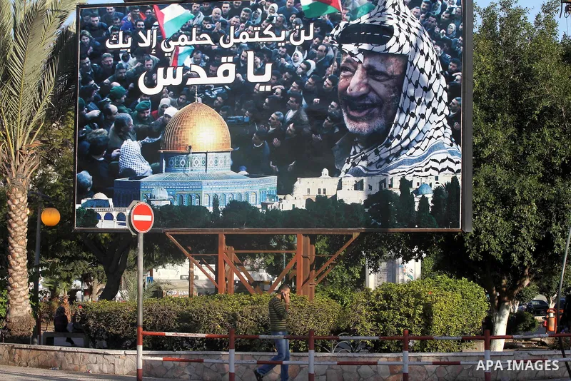 A Palestinian man walks next to a huge poster of late Palestinian leader Yasser Arafat in Gaza city, on 11 November 2011. Arafat, who spearheaded the Palestinian cause for some four decades, died on 11 November 2004 in a...