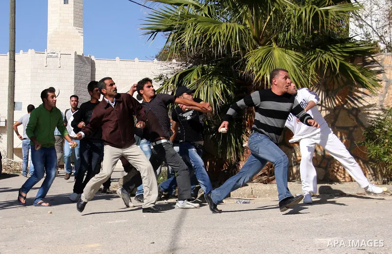 Palestinian protestors hurl stones toward Israeli forces during a weekly demonstration against Israeli-occupation in the northern West Bank village of Kfar Kadum, on November 11, 2011. The Palestinian leadership is unsur...