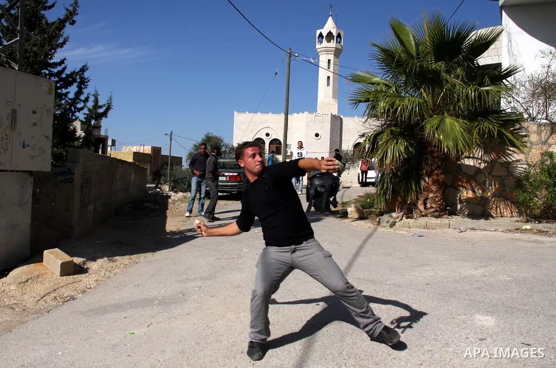 Palestinian protestors hurl stones toward Israeli forces during a weekly demonstration against Israeli-occupation in the northern West Bank village of Kfar Kadum, on November 11, 2011. The Palestinian leadership is unsur...