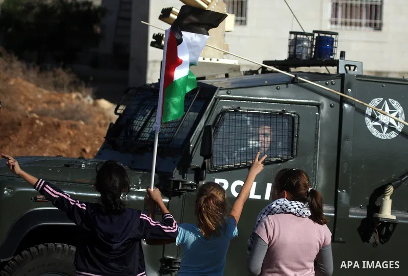 A Palestinian girl holds a Palestinian flag during clashes between Israeli security forces and Palestinian demonstrators at a weekly protest in the West Bank village of Nabi Saleh, near Ramallah November 11, 2011.. Photo...
