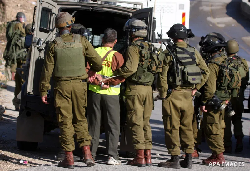 Israeli soldiers detain a Palestinian cameraman, Bilal Tamimi, during clashes between Israeli security forces and Palestinian demonstrators at a weekly protest in the West Bank village of Nabi Saleh, near Ramallah Novemb...
