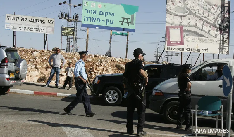 Israeli soldiers stand guard as Palestinian demonstrators take part in a protest in the mostly Arab Jerusalem neighbourhood of Enata on Nov.11,2011. Photo by Mahfouz Abu Turk