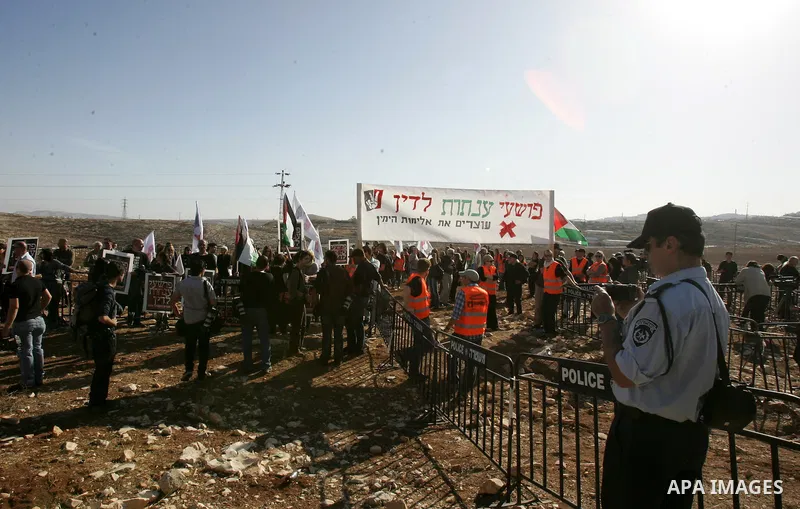 Israeli soldiers stand guard as Palestinian demonstrators take part in a protest in the mostly Arab Jerusalem neighbourhood of Enata on Nov.11,2011. Photo by Mahfouz Abu Turk