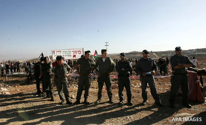 Israeli soldiers stand guard as Palestinian demonstrators take part in a protest in the mostly Arab Jerusalem neighbourhood of Enata on Nov.11,2011. Photo by Mahfouz Abu Turk