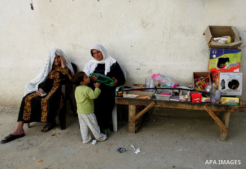 Palestinian woman sit outside their house in Rafah refugee camp in the southern Gaza Strip on Nov.12, 2011. According to a member of the Executive Committee of the Palestine Liberation Organisation Saeb Erekat, there is...
