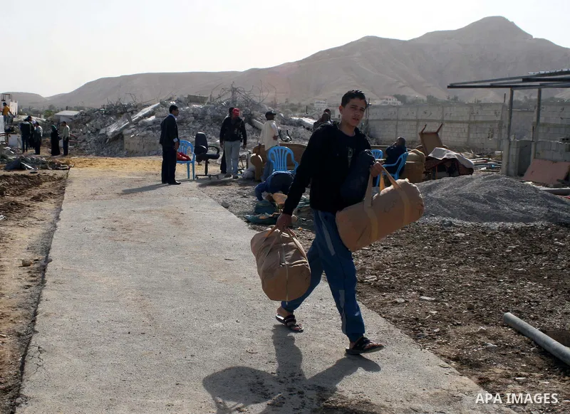 Palestinians check belongings scattered on the ground after Israeli bulldozers razed four Palestinian homes near the ancient city of Jericho on November 15, 2011 with Israel saying they endangered a nearby archaeological...