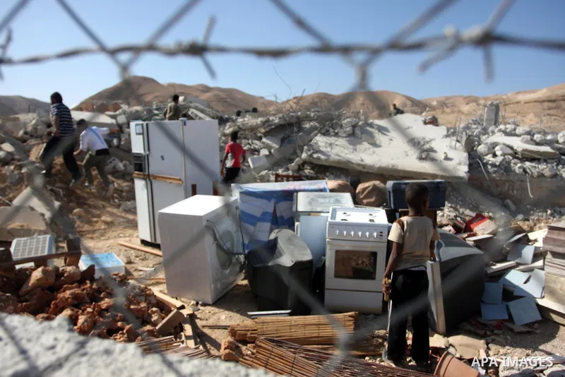 Palestinians check belongings scattered on the ground after Israeli bulldozers razed four Palestinian homes near the ancient city of Jericho on November 15, 2011 with Israel saying they endangered a nearby archaeological...