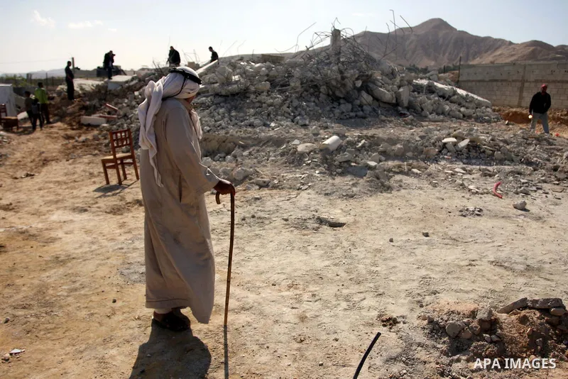 Palestinians check belongings scattered on the ground after Israeli bulldozers razed four Palestinian homes near the ancient city of Jericho on November 15, 2011 with Israel saying they endangered a nearby archaeological...