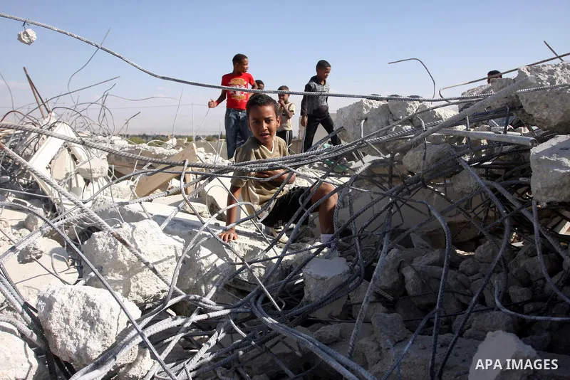 Palestinians check belongings scattered on the ground after Israeli bulldozers razed four Palestinian homes near the ancient city of Jericho on November 15, 2011 with Israel saying they endangered a nearby archaeological...