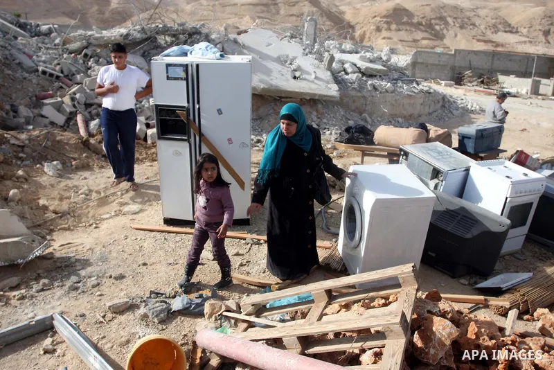 Palestinians check belongings scattered on the ground after Israeli bulldozers razed four Palestinian homes near the ancient city of Jericho on November 15, 2011 with Israel saying they endangered a nearby archaeological...