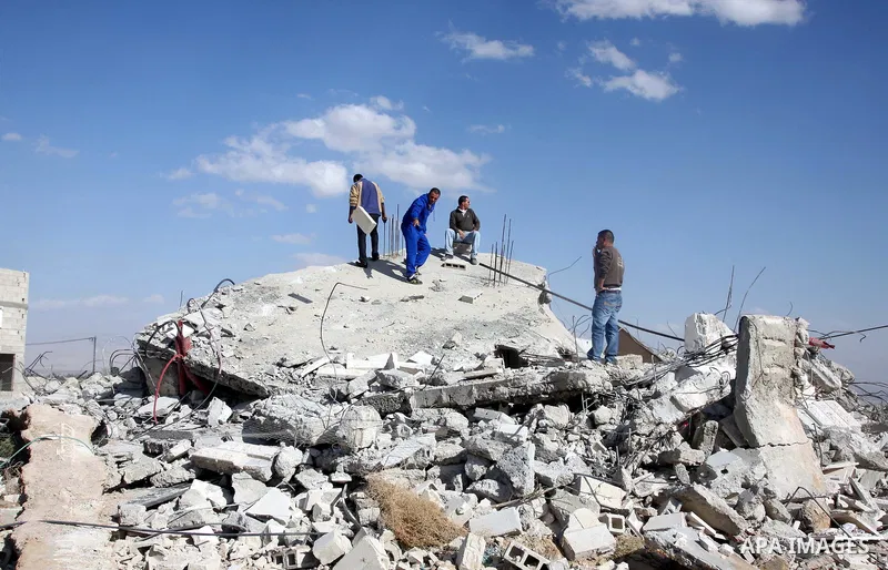 Palestinians check belongings scattered on the ground after Israeli bulldozers razed four Palestinian homes near the ancient city of Jericho on November 15, 2011 with Israel saying they endangered a nearby archaeological...