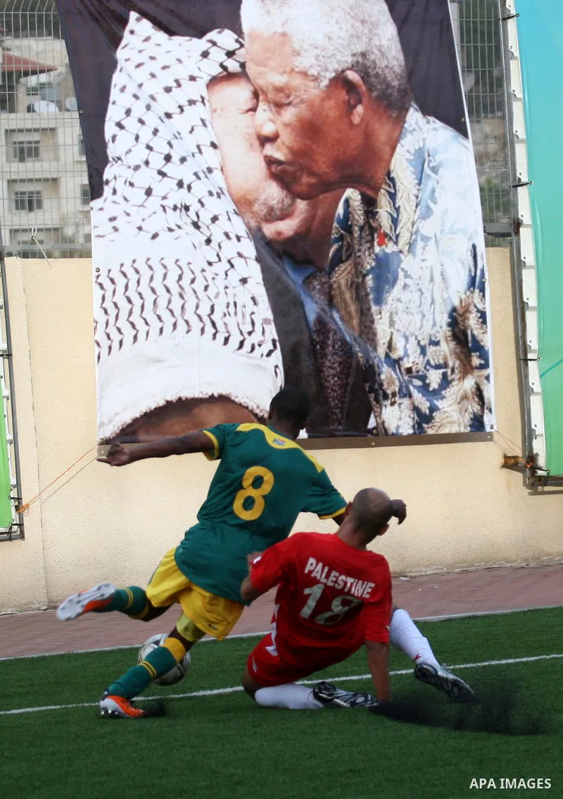South African (Green) and Palestinian (Red) football players fight for the ball during football match in the West Bank town of Nablus, on Nov. 15, 2011. The match ended in 1-1draw. Photo by Wagdi Eshtayah