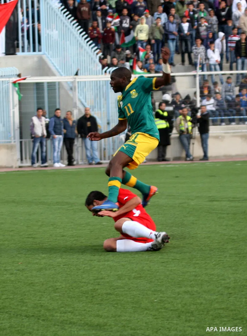 South African (Green) and Palestinian (Red) football players fight for the ball during football match in the West Bank town of Nablus, on Nov. 15, 2011. The match ended in 1-1draw. Photo by Wagdi Eshtayah