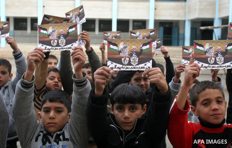 A Palestinian children holds posters of Palestinian President Mahmoud Abbas during a rally in the West Bank city of Nablus on Nov. 16, 2011 . Photo by Wagdi Eshtayah