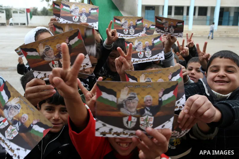 A Palestinian children holds posters of Palestinian President Mahmoud Abbas during a rally in the West Bank city of Nablus on Nov. 16, 2011 . Photo by Wagdi Eshtayah